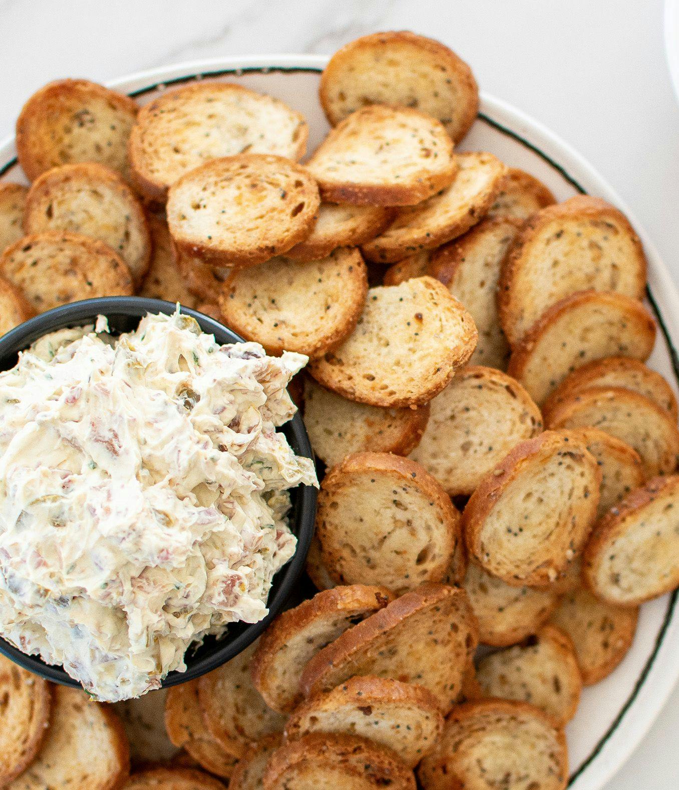 Jalapeño Bacon Cream Cheese Dip on a plate with bagel chips.