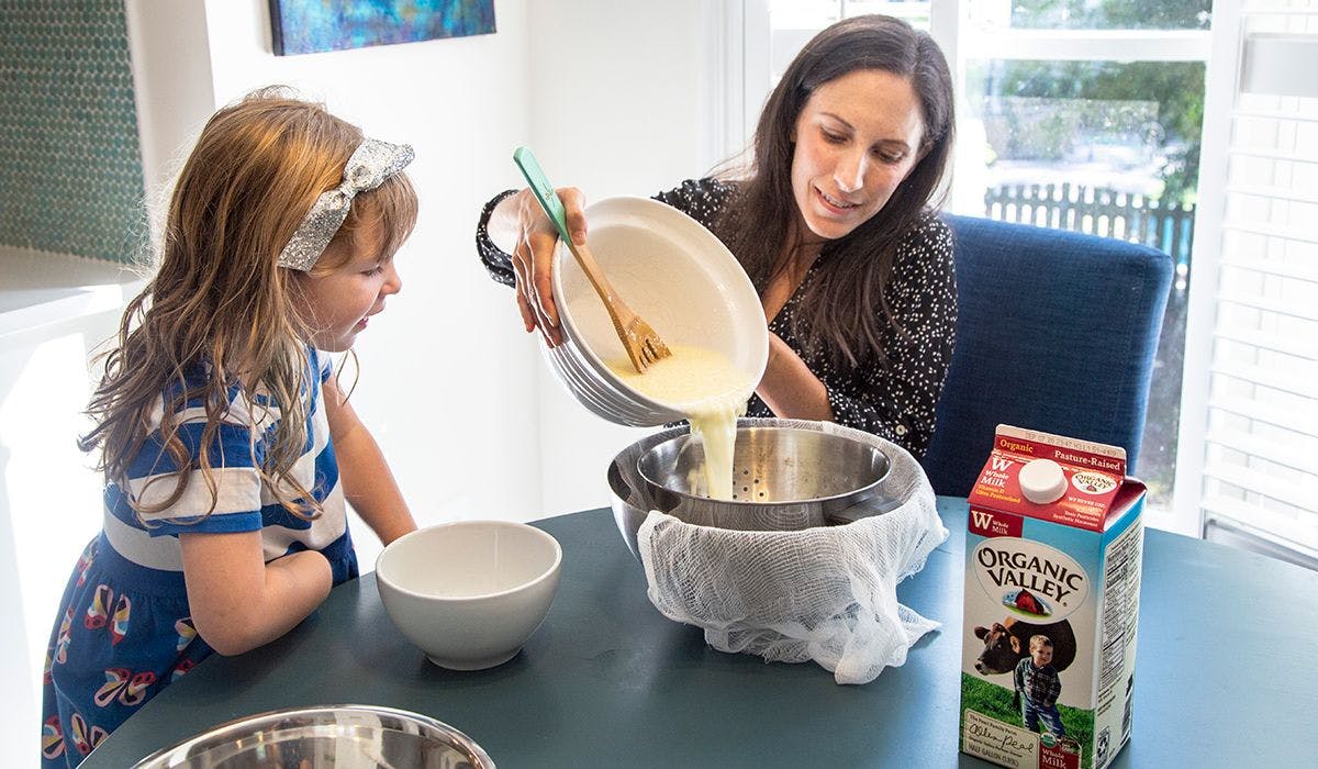Mom and daughter make organic ricotta cheese together. Photo by Jackie Stofsick.