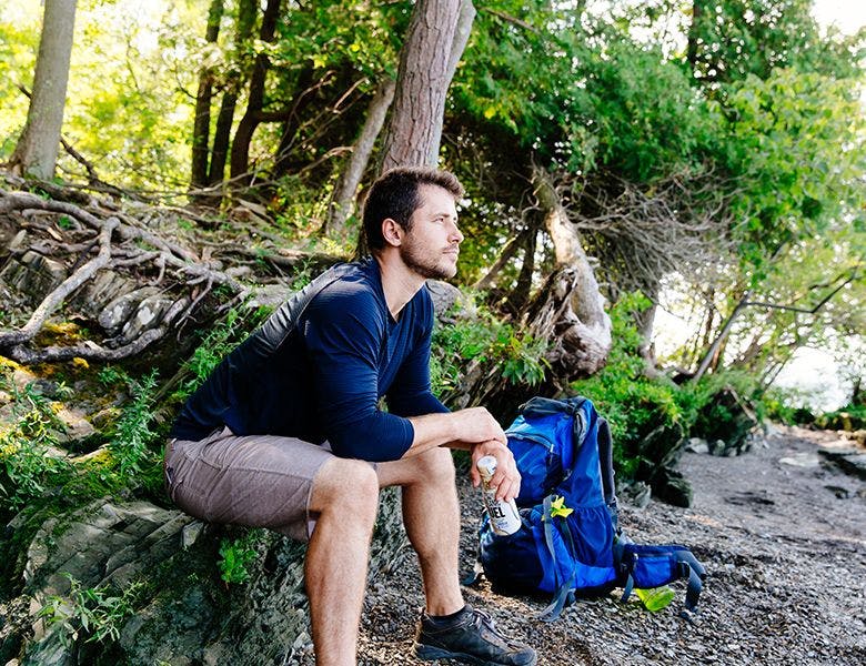 A man relaxing in the woods during a hike.
