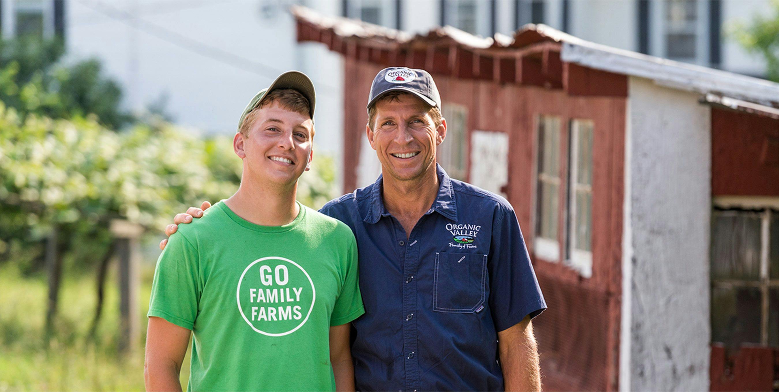 Father and son, Ron and Adam Holter, standing proudly outside of their family barn.