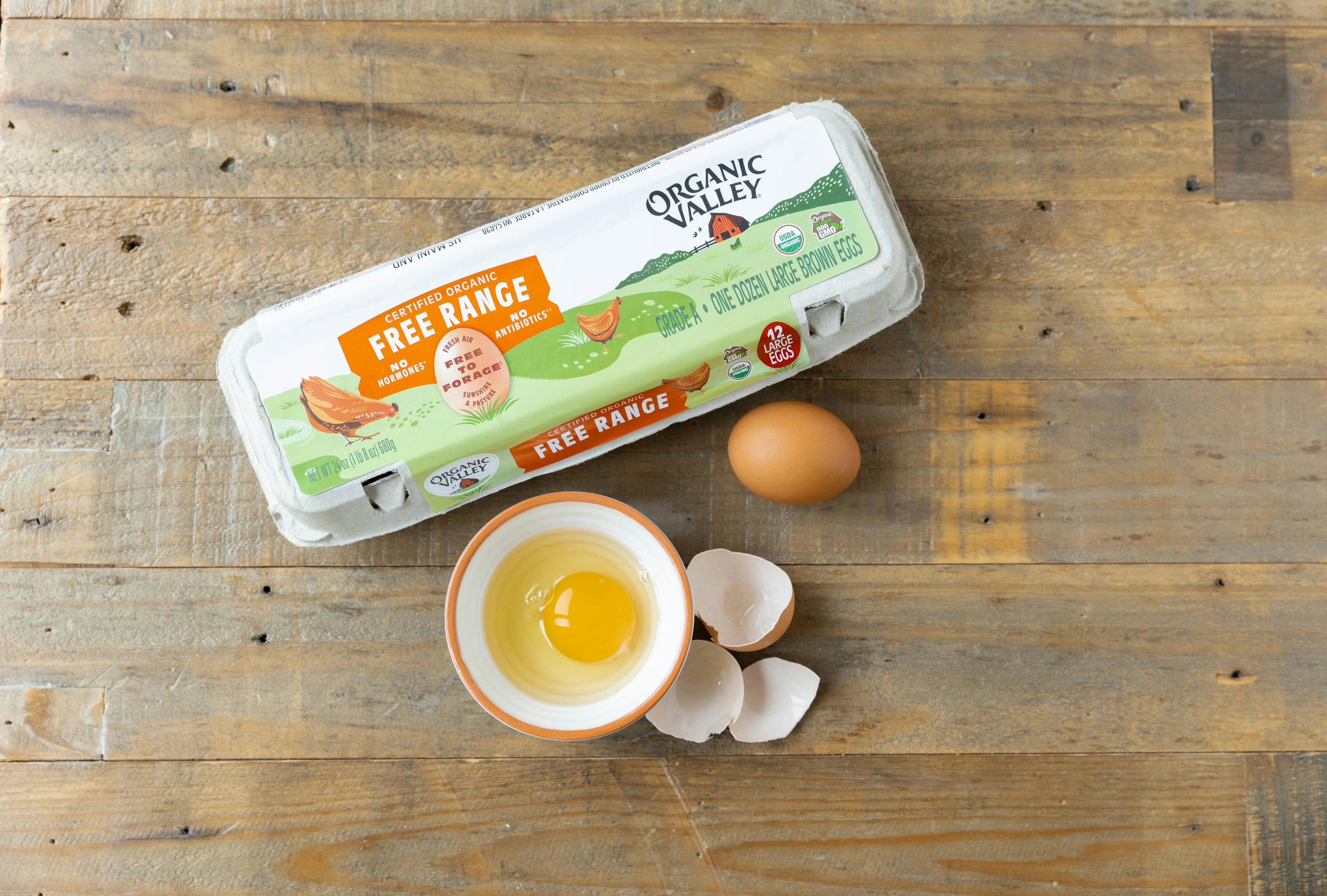 An egg in a dish next to a carton of Organic Valley free range eggs.