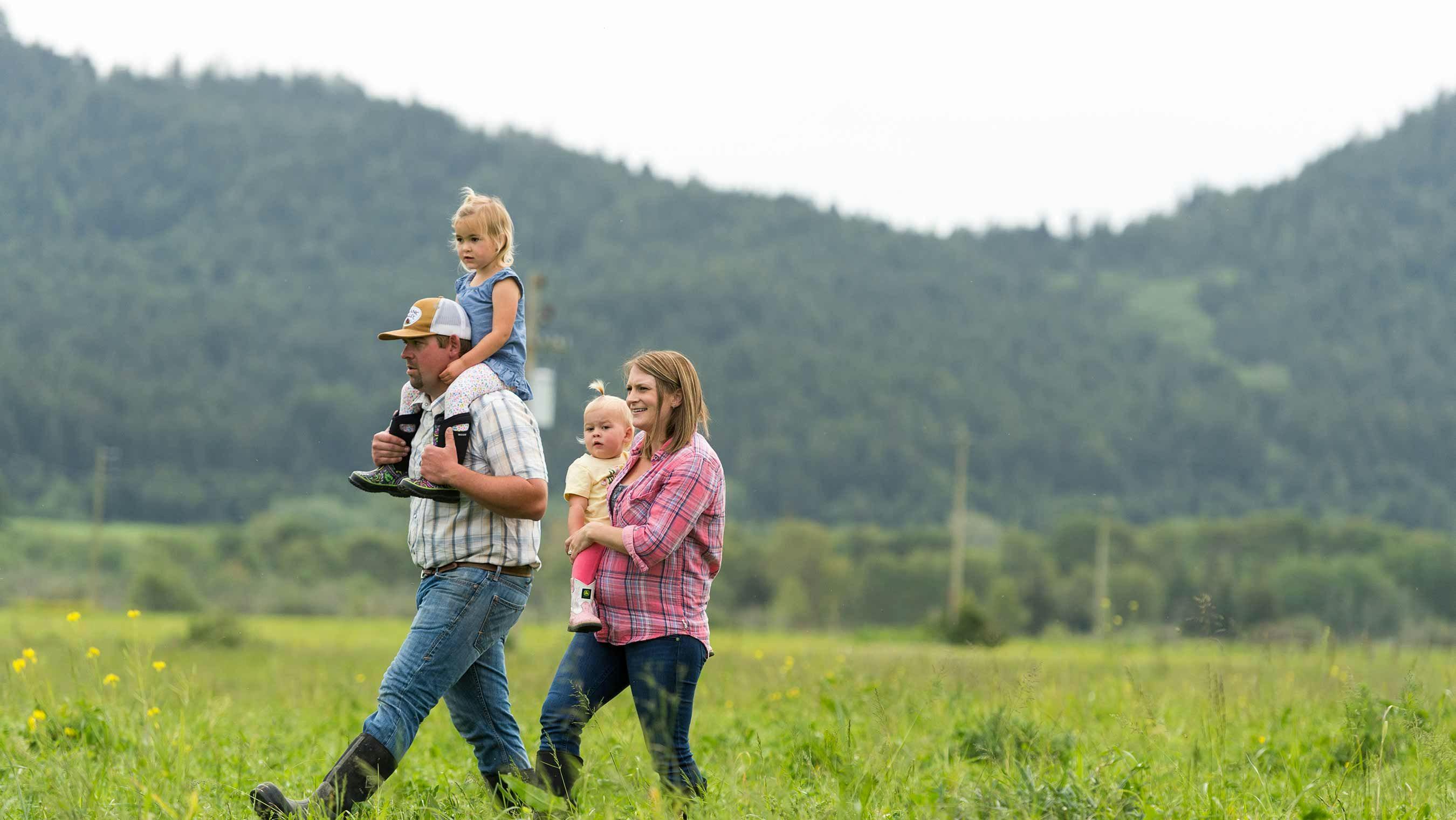 The Bess family walking in the pasture on their Organic Valley family farm