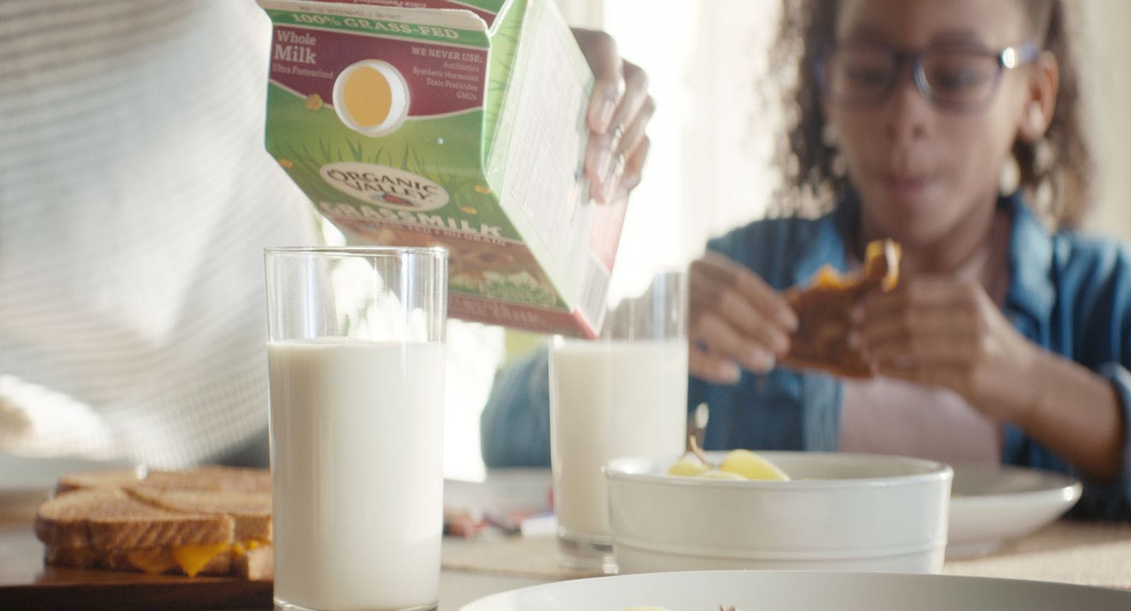 Grassmilk organic milk is poured into glasses on the kitchen table.