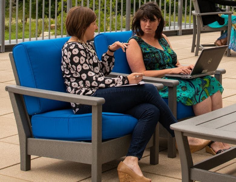 Two employees discussing work outside on Organic Valley's patio.