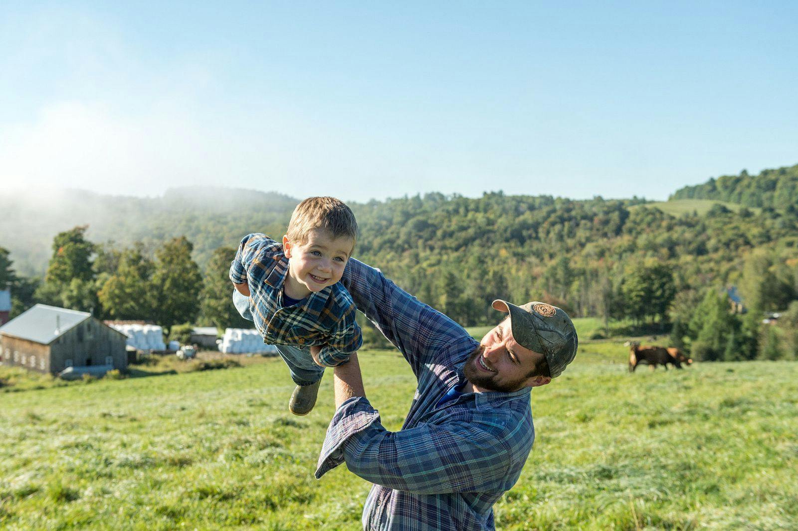Organic Valley farmer, Henry Pearl, and his son take time to play in the pasture at their organic farm in Vermont.