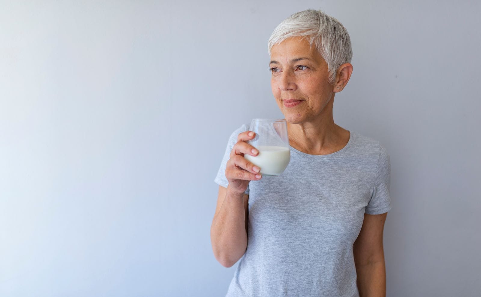 A woman holds a glass of milk.