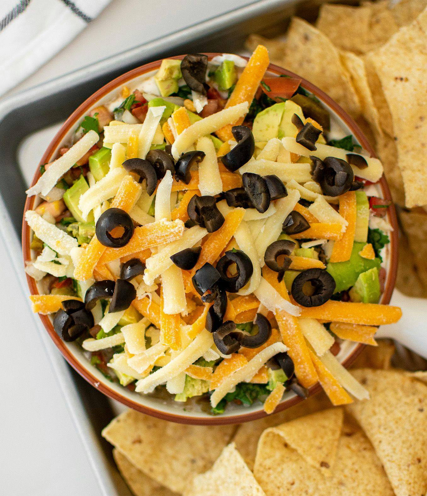 Easy Taco Bean Dip in a bowl surrounded by nacho chips.